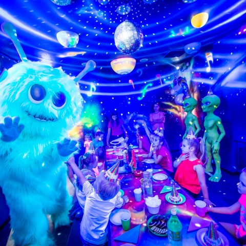 Kosmiczna maskotka bawi się z dziećmi podczas imprezy urodzinowej w Airo Space Kids